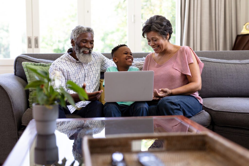 boy and his grandparents using a laptop