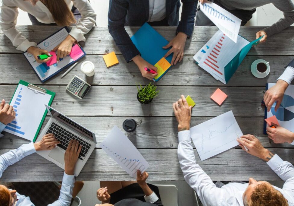 Business corporate management planning team concept, people sitting around office table and working with financial data reports